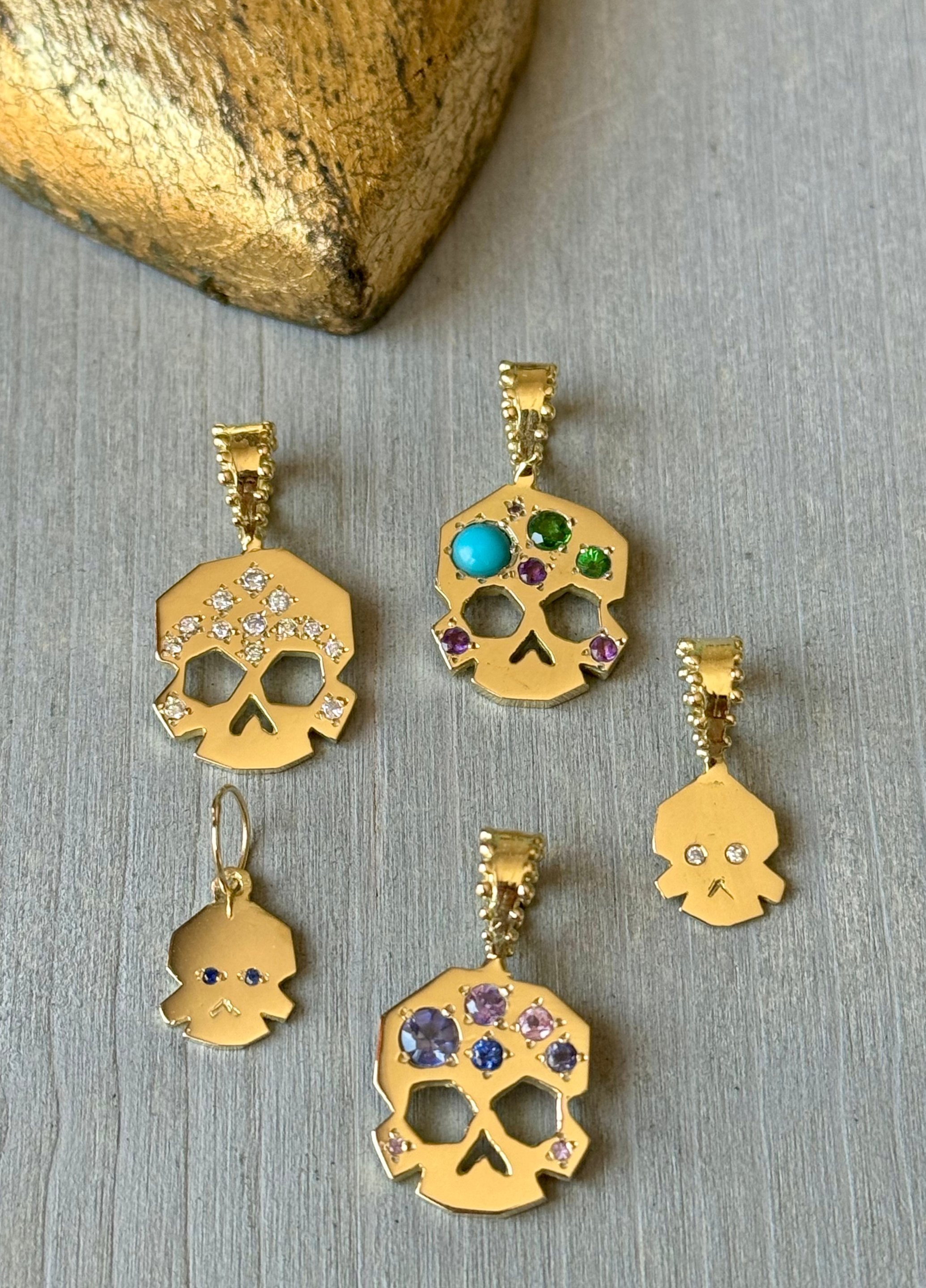 A circle of 5 Delphine Leymarie Facette Skulls in soldi 18k yellow recycled gold and assorted gemstones
