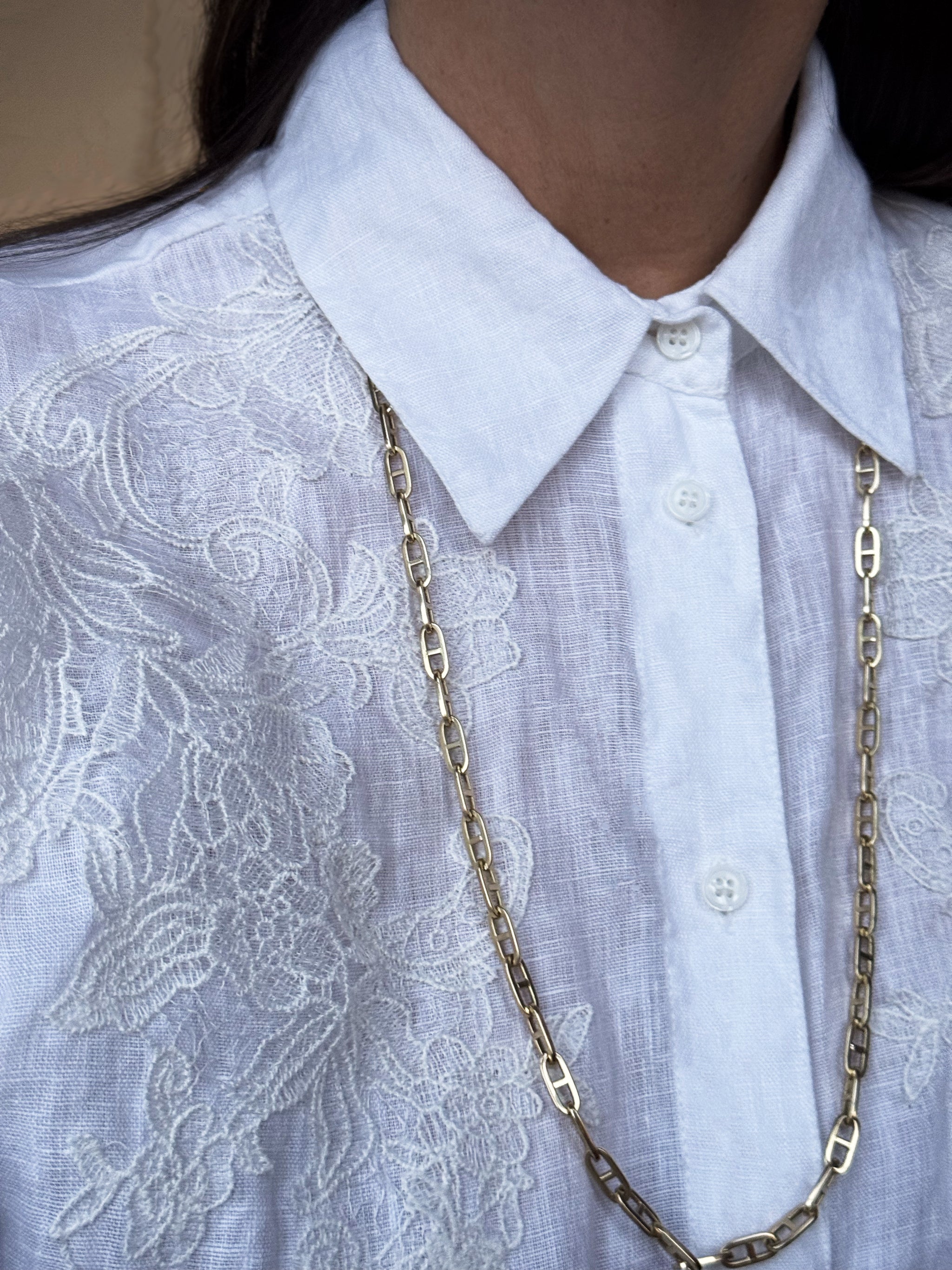 30" Boheme Grande Marine Chain by Delphine Leymarie in 14k yellow gold styled as a double-wrap necklace over a white embroidered linen shirt