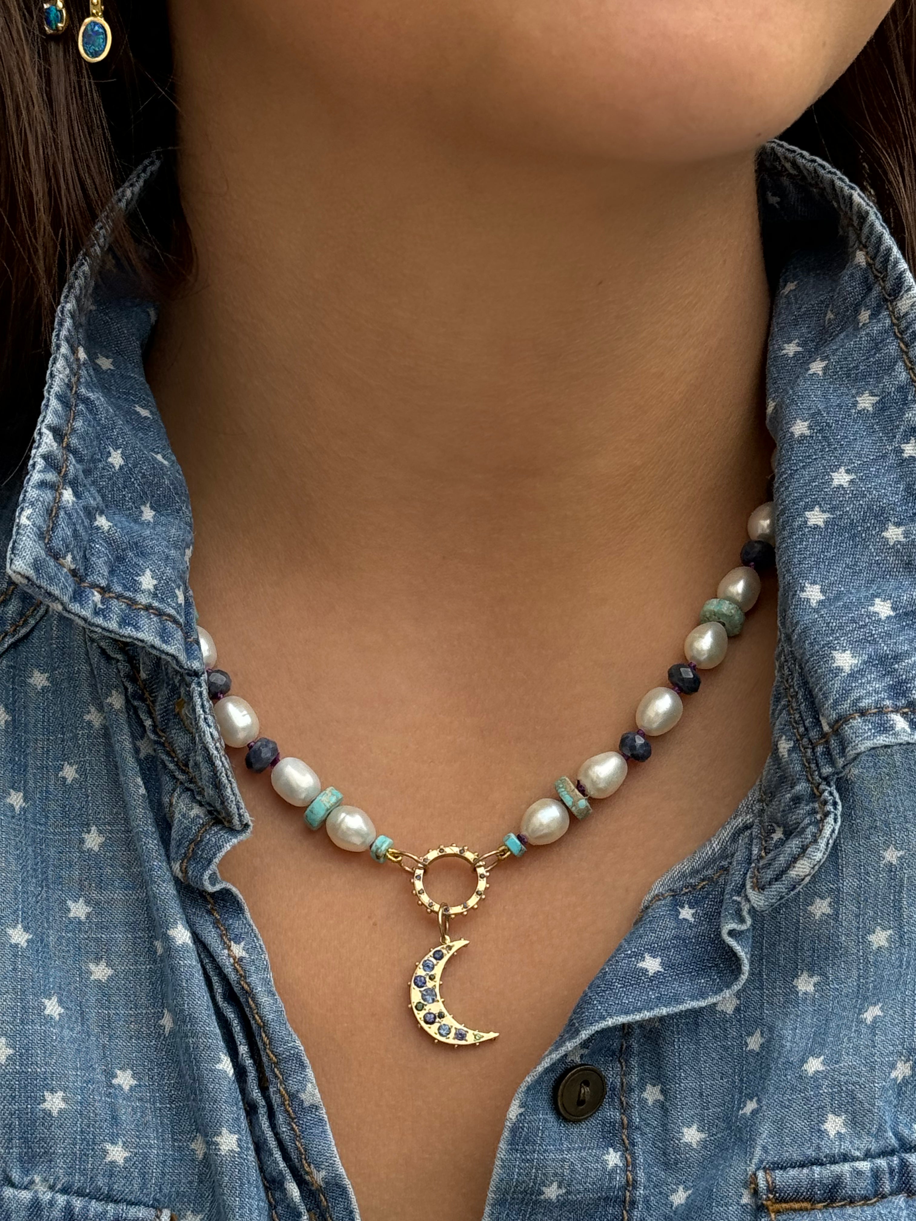 Hand carved 18k recycled yellow gold crescent charm with Blue purple sapphires, green tsavorite and amethyst on model