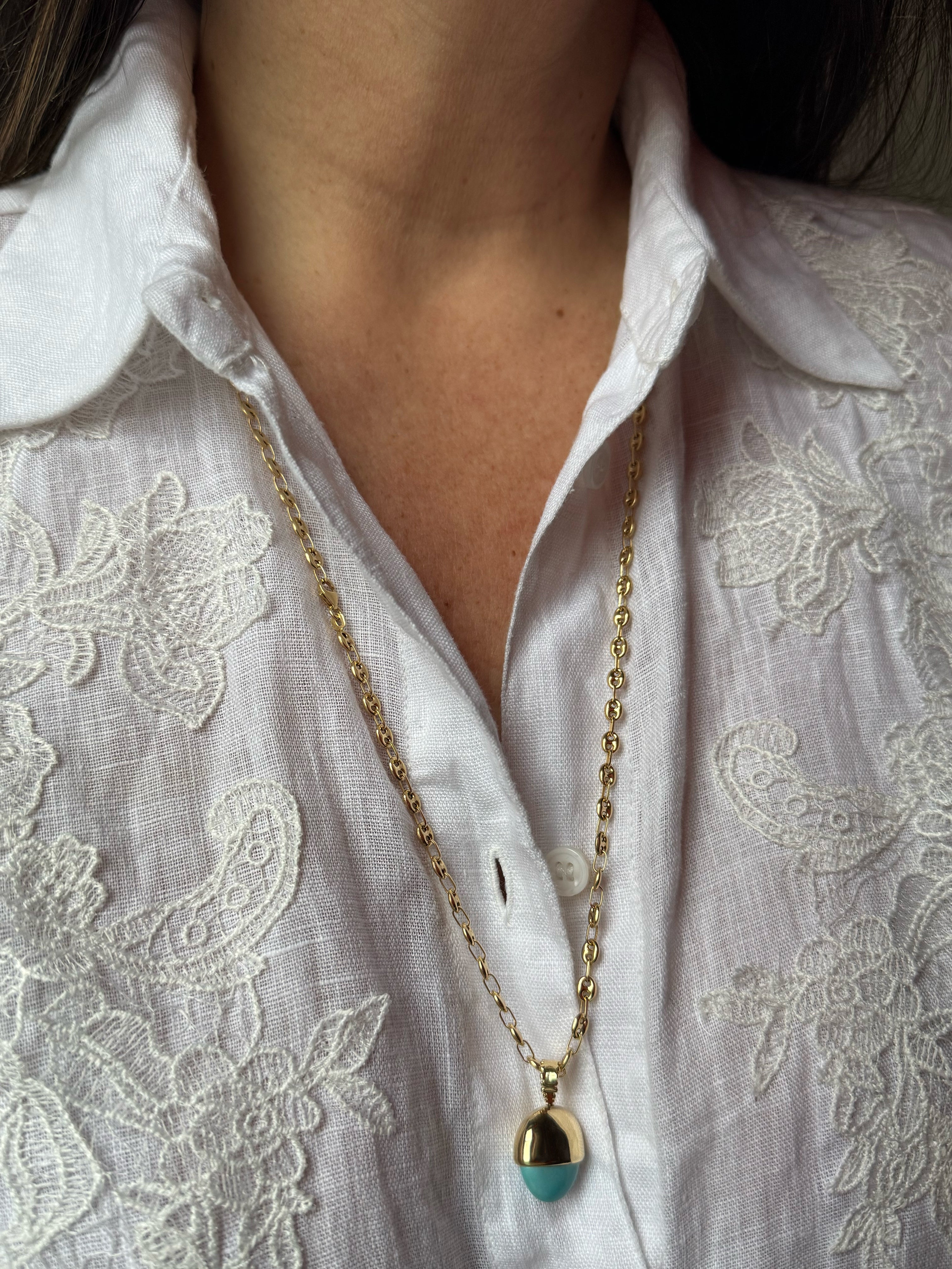 SeaSpell Le Pendule turquoise and 18k gold pendulum necklace styled on anchor chain over embroidered white linen shirt.