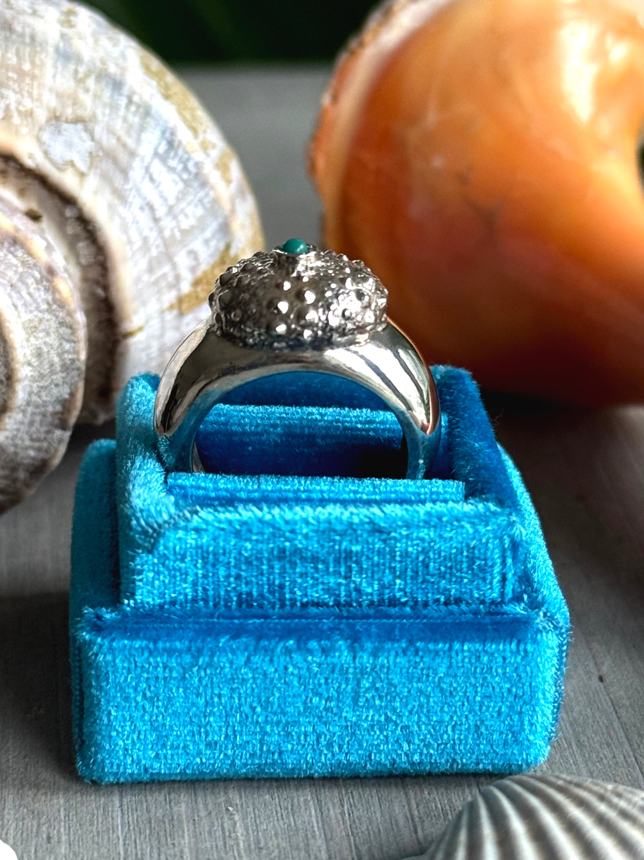 Profile of Turquoise Sea Urchin Ring on blue velvet ring box, bold silver spikes symbolizing protection and resilience.
