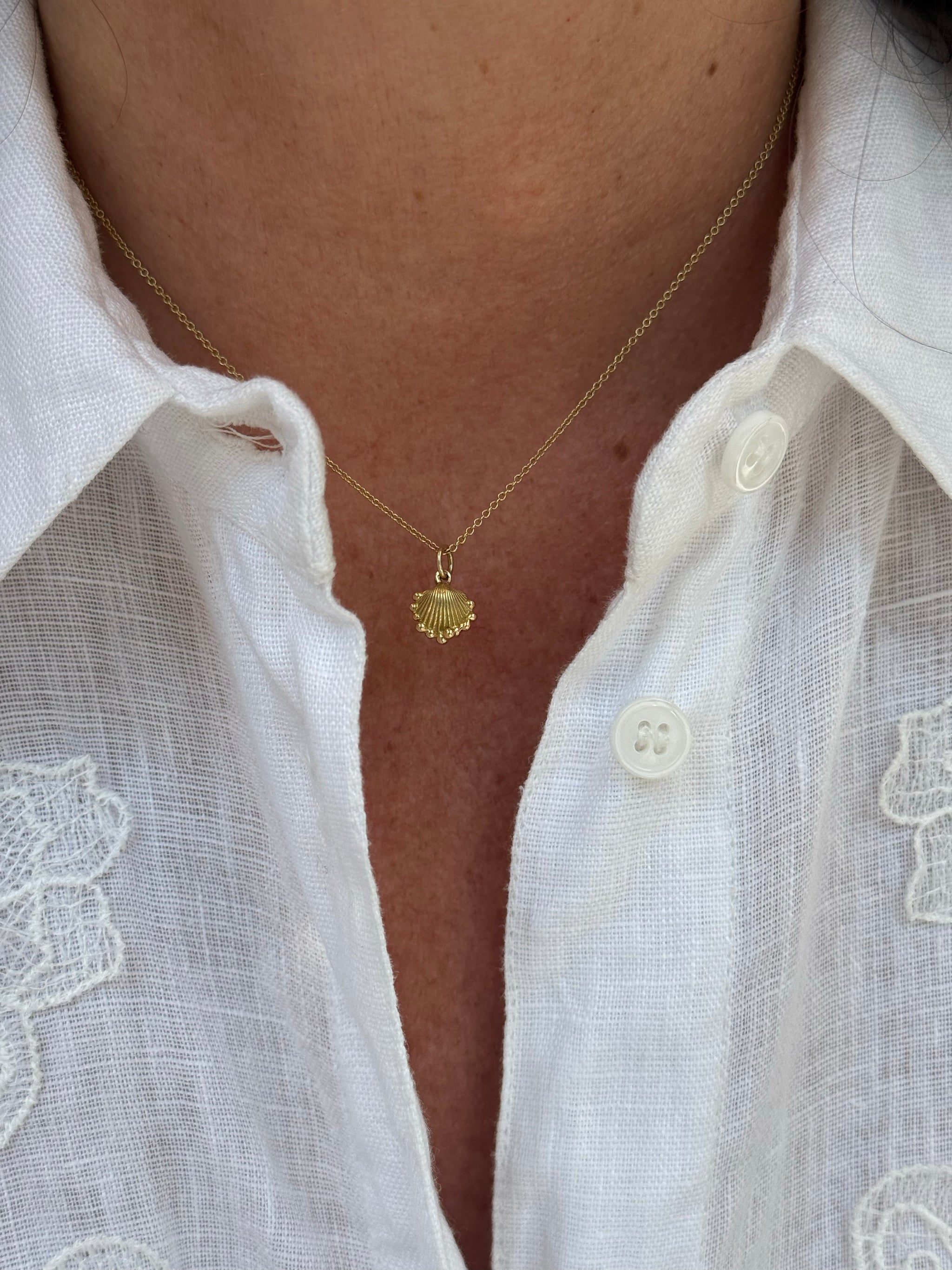 Petite Shell charm in solid 18k recycled yellow gold worn on a fine gold chain