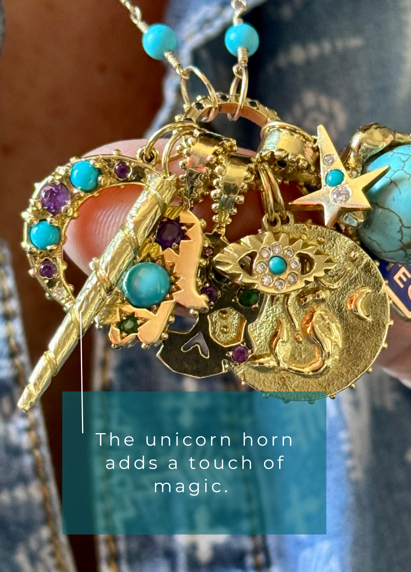 18k solid recyceld gold Boheme Sapphire Clicker charm holder with various charms and talismans including a unicorn horn, held by a person.