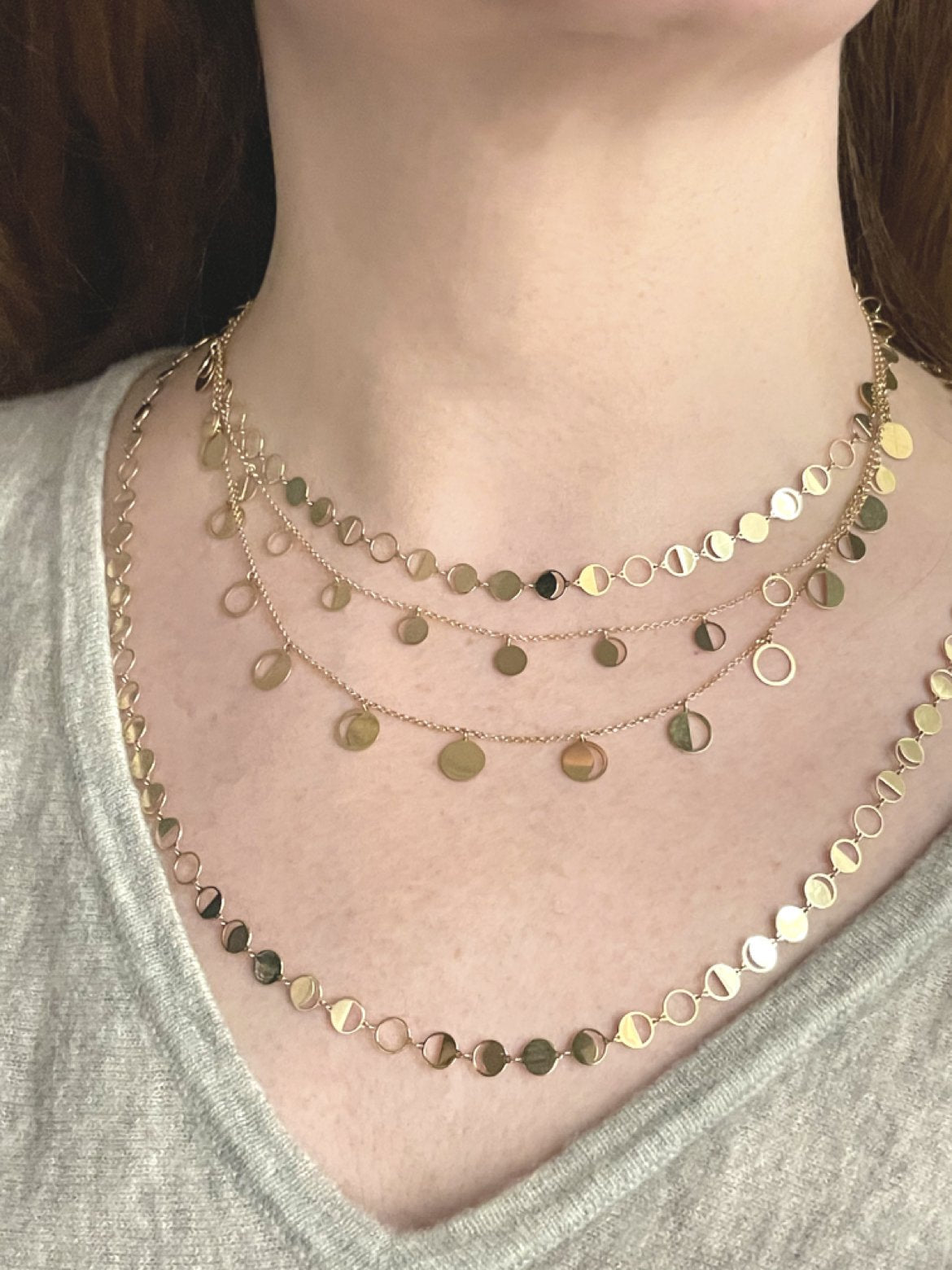 Solid 18k yellow gold Confetti Lune Petite and Regular diecut Moon Phase Chains layered on a Model's neck
