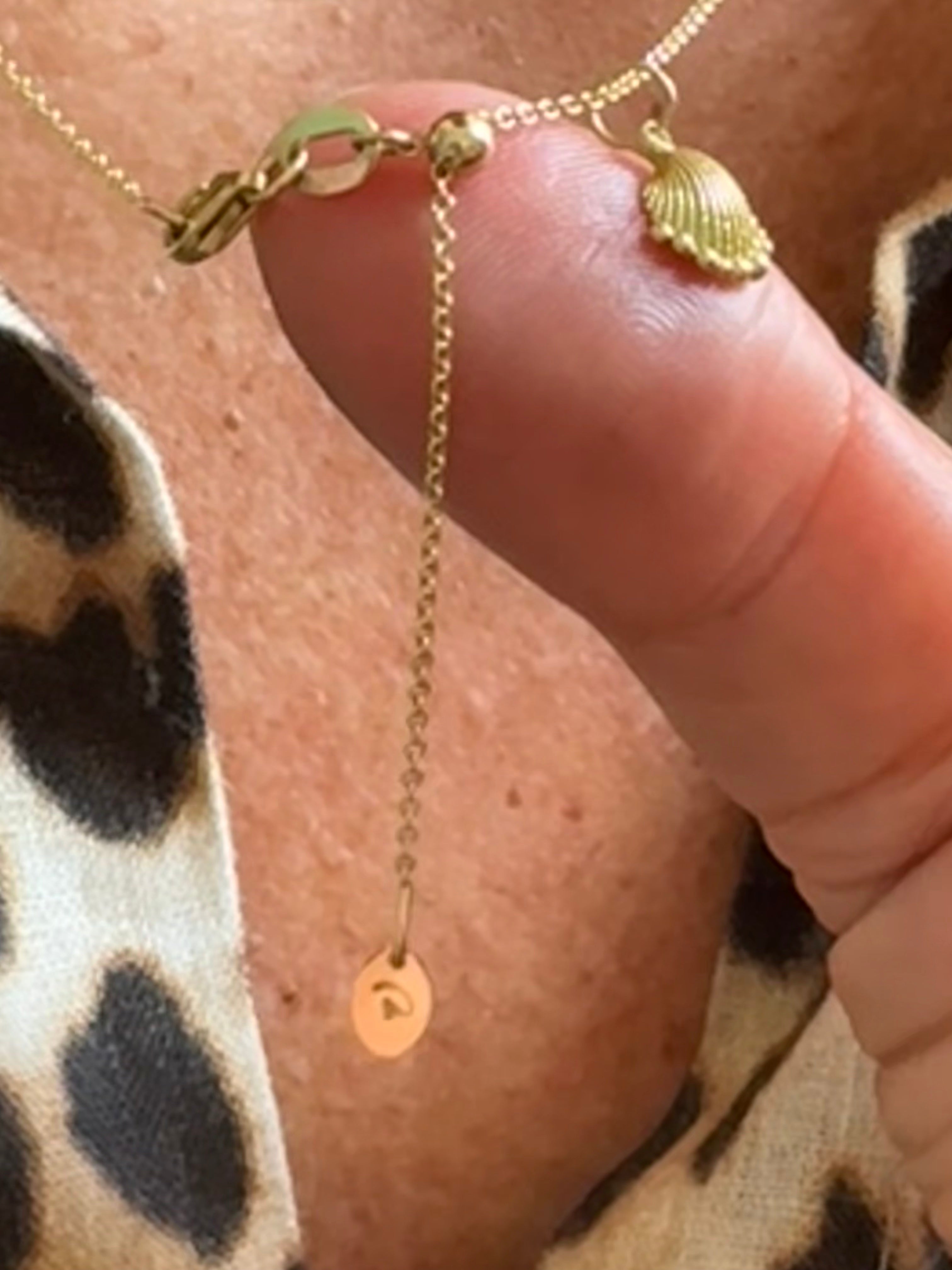 Close-up of Delphine Leymarie adjustable 18k gold cable chain, showing sliding bead and Petite Shell charm.